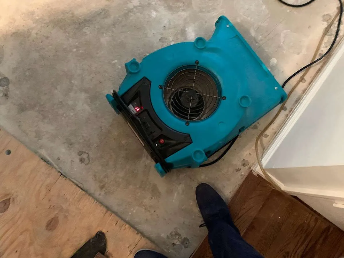Air mover drying subfloor during Commercial Water Damage Restoration in Moline